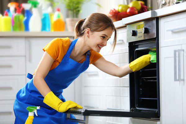 Girl cleaning the oven