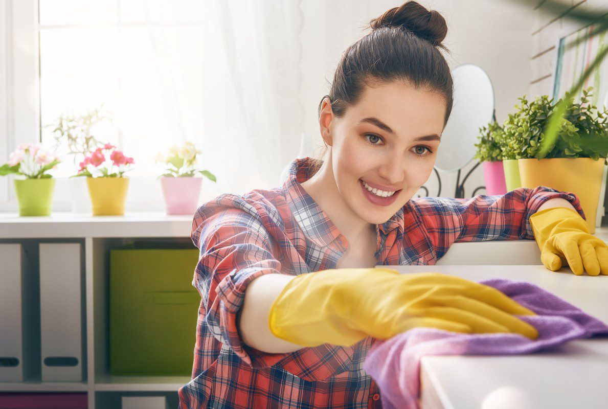 Girl cleaning the table with her gloves on